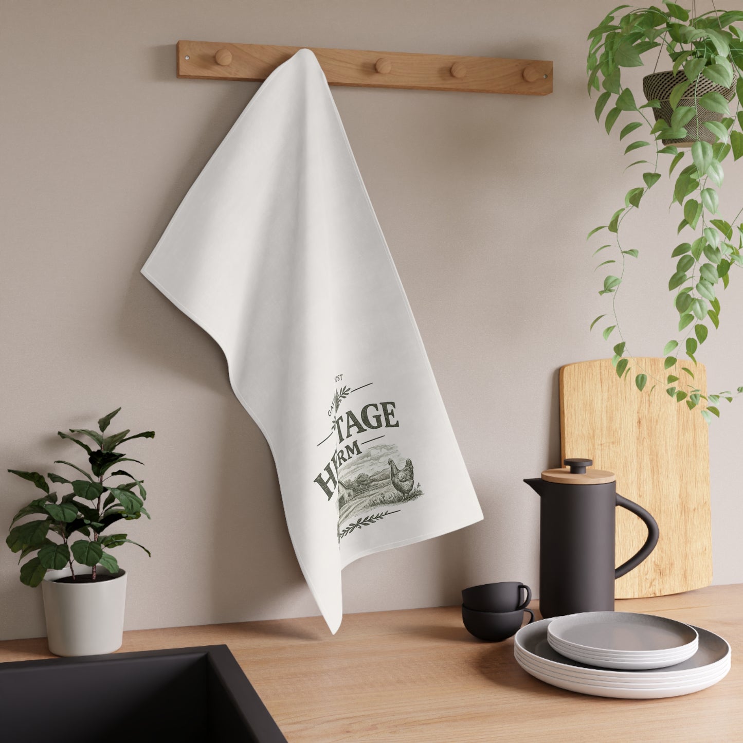 White towel with vintage farm design hanging on a wooden rack in a kitchen setting.