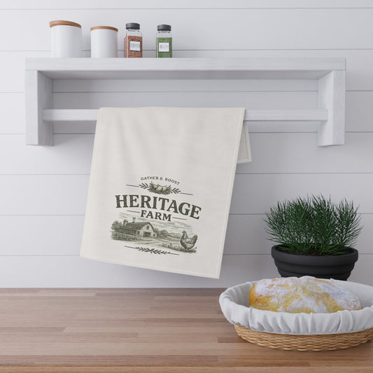 Kitchen towel with 'Heritage Farm' design hanging on a shelf above a wooden counter.